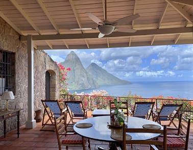 A patio with chairs and tables overlooking the ocean.