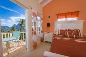 A bedroom with an ocean view and orange walls.